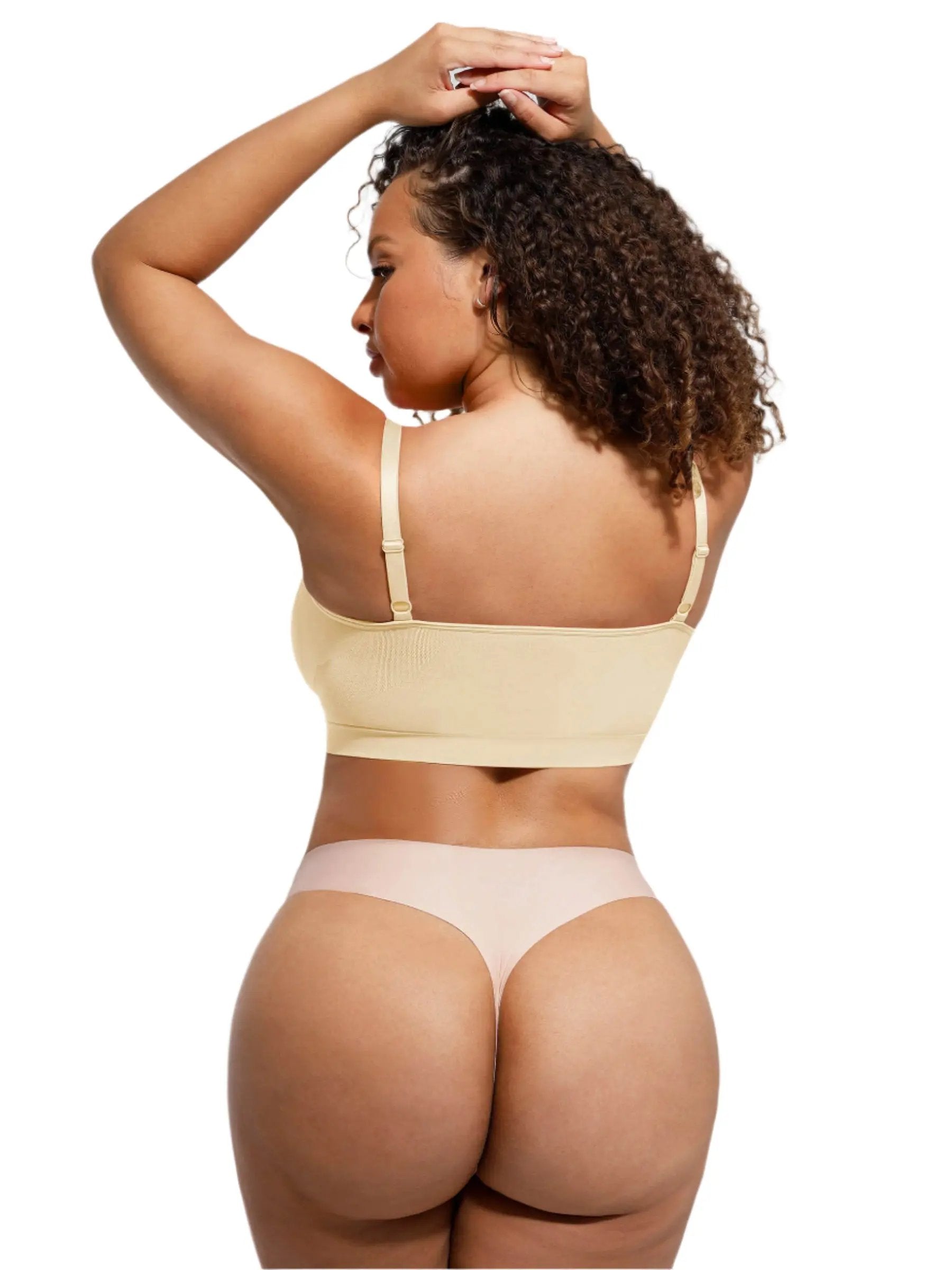 Woman wearing a beige bikini set against a plain background